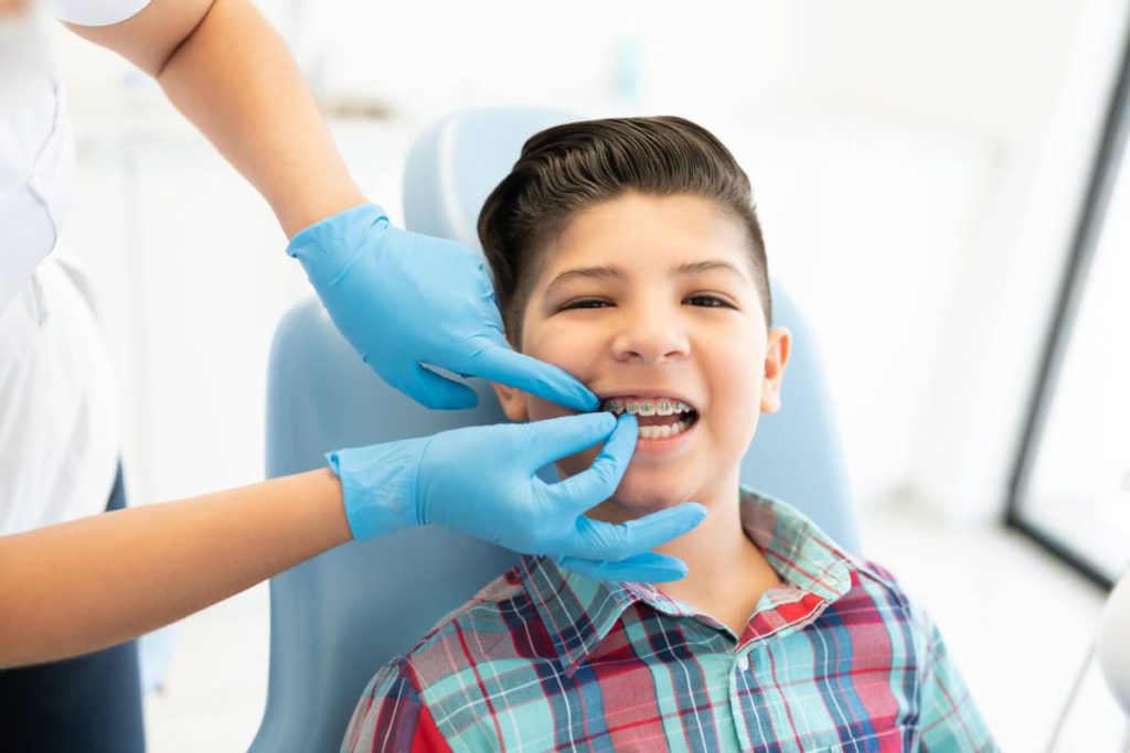 Dentist helping a kid adjust to braces.